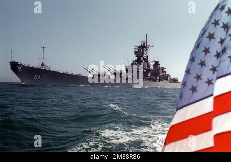 Ein Hafenbogenblick auf das im Gange befindliche Schlachtschiff USS IOWA (BB-61). Der nationale Fähnrich ist im Vordergrund sichtbar. Land: Unbekannt Stockfoto