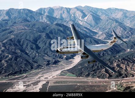 Luft-Luft, Seitenansicht des C-141B Starlifters eines 63. Airlift Wings, „Spirit of the Inland Empire“, wenn es sich nach links bewegt, mit den San Bernardino Bergen im Hintergrund, für die Landung in Norton. Exaktes Datum Aufnahme Unbekannt. Basis: Luftwaffenstützpunkt Norton Bundesstaat: Kalifornien (CA) Land: Vereinigte Staaten von Amerika (USA) Stockfoto