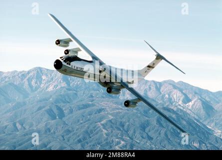 Luft-Luft, Seitenansicht des C-141B Starlifters eines 63. Airlift Wings, „Spirit of the Inland Empire“, wenn es sich nach links bewegt, mit den San Bernardino Bergen im Hintergrund, für die Landung in Norton. Exaktes Datum Aufnahme Unbekannt. Basis: Luftwaffenstützpunkt Norton Bundesstaat: Kalifornien (CA) Land: Vereinigte Staaten von Amerika (USA) Stockfoto