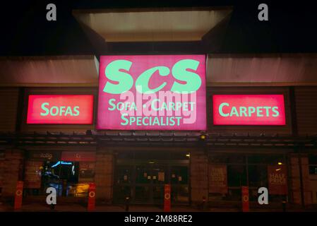 SCS Sofa Teppichspezialisten-Schild über dem Haupteingang bei Nacht ohne Leute Great Western Retail Park1 Allerdyce Rd, Glasgow G15 6RX Stockfoto