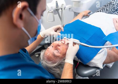 Zahnklinik, ältere Frau am Zahnarzt mit Arzt bei Routineuntersuchung von Zahnersatz Stockfoto