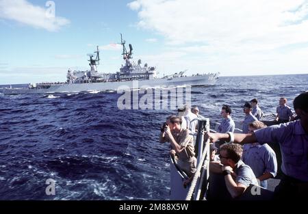 Besatzungsmitglieder des Schlachtschiff USS IOWA (BB-61) schauen über die Schiene, während der geführte Raketenkreuzer USS HORNE (CG-30) vorbeifährt. Land: Unbekannt Stockfoto