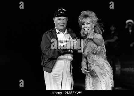 Komiker Bob Hope und Entertainerin Barbara Eden unterhalten Besatzungsmitglieder des Amphibienschiffs USS OKINAWA (LPH-3) während einer Weihnachtsshow der United Services Organization für Seeleute, die den Golf patrouillieren. Das Schiff ist vor der Küste Bahrains vor Anker. Land: Unbekannt Stockfoto