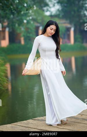 Ho Chi Minh City, Vietnam: AO Dai ist ein traditionelles vietnamesisches Kleid, eine wunderschöne vietnamesische Frau in weißem Ao Dai-Kleid im Park Stockfoto