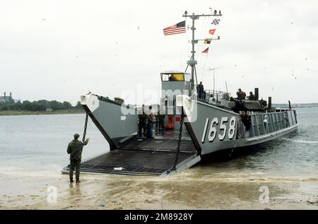 Marinestützpunkt Amphibienfahrzeug. Ein Backbord-Bugblick des Versorgungsschiffes LCU-1658 mit abgesenkter Rampe. Auf dem Deck der LCU befindet sich ein Hauptkampfpanzer der Marine M-1A1, ausgestattet mit einem Fording Kit, das vom Marine Corps evaluiert wird. Basis: Naval Amphib Base, Little Creek Bundesstaat: Virginia (VA) Land: Vereinigte Staaten von Amerika (USA) Stockfoto