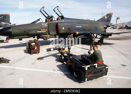 Mitglieder einer 37. taktischen Kampfflugzeugcrew verwenden einen MJ-1-Waffenlader, um eine AGM-45-Abstrahlungsrakete aus einem 563. taktischen Kampffluggeschwader F-4E Phantom II zu entfernen. Basis: George Luftwaffenstützpunkt Bundesstaat: Kalifornien (CA) Land: Vereinigte Staaten von Amerika (USA) Stockfoto