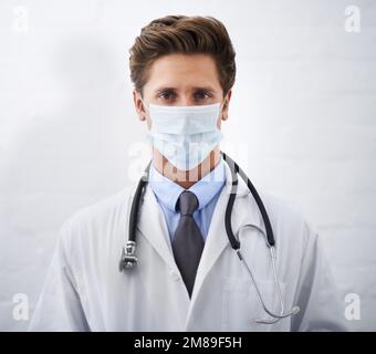 Medizinische Angelegenheiten ernst nehmen. Porträt eines ernsthaft aussehenden jungen Arztes mit einer Operationsmaske. Stockfoto