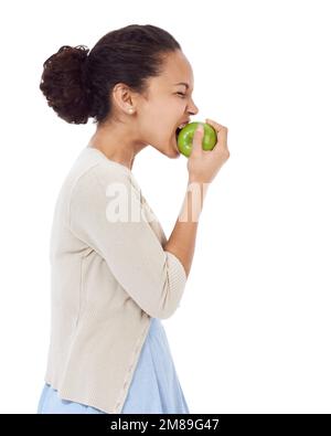 Wow, es ist so schwer. Junge Frau beißt einen frischen Apfel - isoliert auf Weiß. Stockfoto