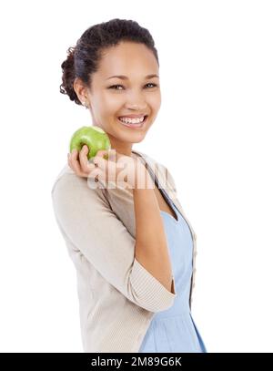 Sie wählt immer die gesunde Option zum Snack. Junge Frau lächelt, während sie einen frischen Apfel hält - isoliert auf Weiß. Stockfoto