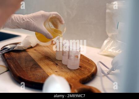 Ich gieße Jojobaöl in die leeren Kosmetikflaschen Stockfoto