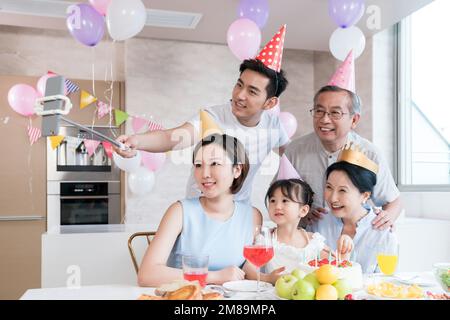 Eine schöne Familienfeier in der Küche mit einem Handy Stockfoto