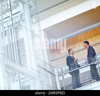 Geschäftsleute, Gespräche und Networking mit Kommunikation, Meetings und Zusammenarbeit auf dem Balkon am Flughafen oder im Büro. Partnerschaft, Geschäftstreffen oder Stockfoto