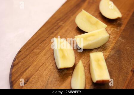 Äpfel in Scheiben auf dem Holzbrett schneiden Stockfoto