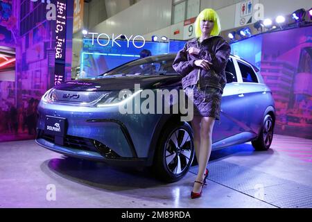 A model poses near an electric vehicle DOLPHIN, one of the latest cars from Chinese auto manufacturer BYD at the Tokyo Auto Salon, an industry event similar to the world's auto shows, Friday, Jan. 13, 2023, in Chiba near Tokyo. (AP Photo/Eugene Hoshiko)