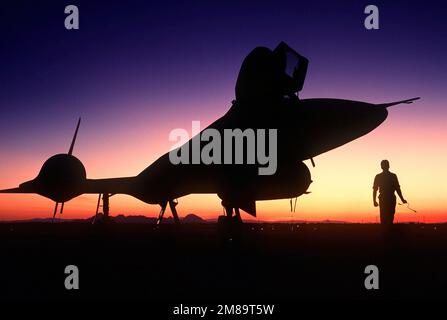 Rechte Vorderansicht eines strategischen Aufklärungsflugzeugs der SR-71B Blackbird, das bei Sonnenuntergang auf der Startbahn steht. Der SR-71 ist inoffiziell als „Blackbird“ bekannt. Basis: Luftwaffenstützpunkt Beale Bundesstaat: Kalifornien (CA) Land: Vereinigte Staaten von Amerika (USA) Stockfoto