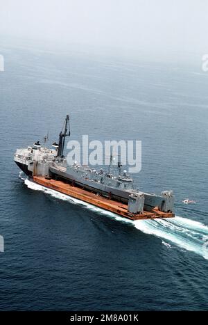 Ein Luftanblick auf das holländische Schwerhubschiff MIGHTY SERVANT 2 mit seiner Fracht, die geführte Raketenfregatte USS SAMUEL B. ROBERTS (FFG-58), die an Deck gesichert ist. Die ROBERTS sind auf dem Weg zu ihrem Heimathafen in Newport, R.I., nachdem sie am 14. April 1988 eine iranische Mine getroffen haben. Land: Unbekannt Stockfoto