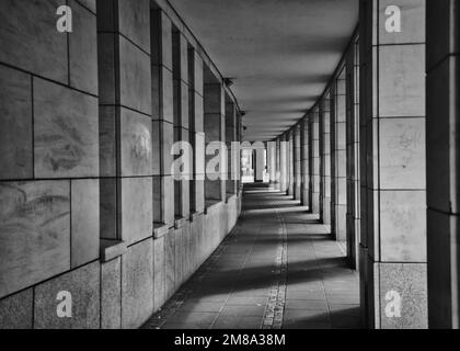 Eine Graustufenaufnahme eines Weges außerhalb eines Gebäudes mit einer wunderschön dekorierten Fassade Stockfoto