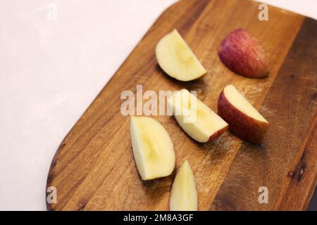 Äpfel in Scheiben auf dem Holzbrett schneiden Stockfoto