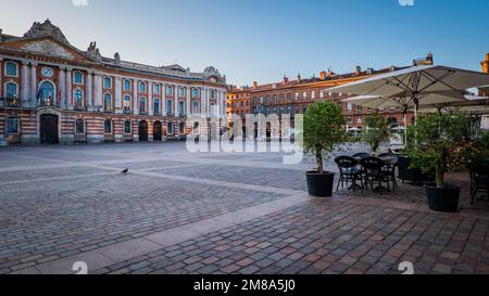 Stühle, Tische und Sonnenschirme einer Café-Terrasse auf dem Capitole-Platz in Toulouse im Süden Frankreichs (Haute Garonne) Stockfoto