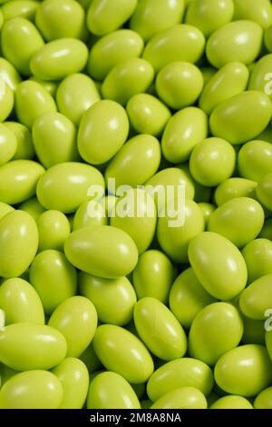 Schokoladendragee in Form eines Haufens. Grüne Dragee-Schokolade, außen mit Zucker bedeckt und innen mit Schokolade gefüllt. Schließen Stockfoto