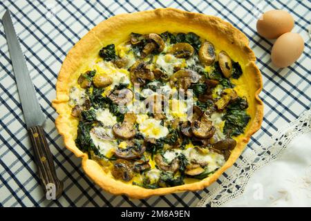 Spinatpilze, französische Quiche. In der Gastronomie ist eine Quiche eine herzhafte Torte, die aus der französischen Quiche lorraine stammt. Stockfoto