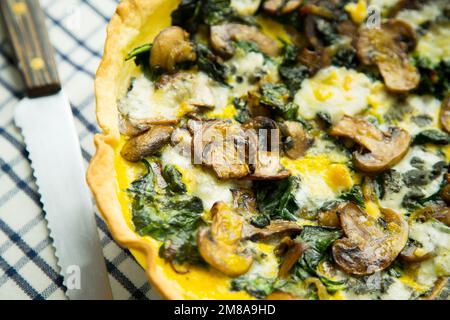 Spinatpilze, französische Quiche. In der Gastronomie ist eine Quiche eine herzhafte Torte, die aus der französischen Quiche lorraine stammt. Stockfoto