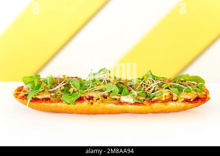 Baguette mit Tomatensoße, Fleisch, Jalapeno und Rucola, gebacken mit Käse. Beliebtes Street Fast Food Stockfoto