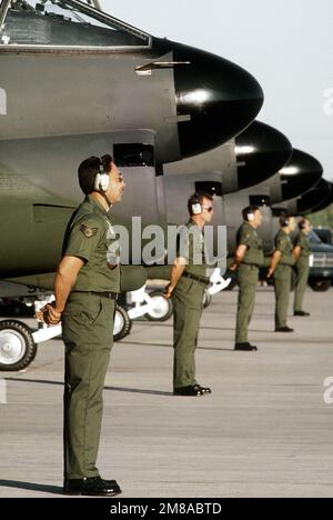 A-7 Corsair II Aircraft Crew Chiefs des taktischen Kampfflügels 140., Colorado Air National Guard, warten auf den Befehl, den Wettkampf während Gunsmoke '87 zu beginnen, einem taktischen Schießkampf und Bombenangriff, der von der taktischen Luftwaffe gesponsert und vom taktischen Kampfwaffenzentrum in Nellis ausgerichtet wird. Betrifft Operation/Serie: GUNSMOKE '87 Stützpunkt: Nellis Luftwaffenstützpunkt Bundesstaat: Nevada (NV) Land: Vereinigte Staaten von Amerika (USA) Stockfoto