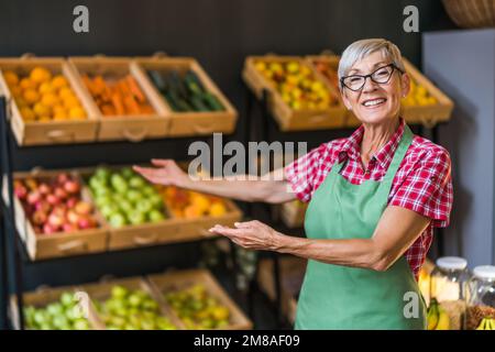 Reife Frau arbeitet im Obst- und Gemüseladen. Porträt des Kleinbetriebs Supermarkt Besitzer. Stockfoto