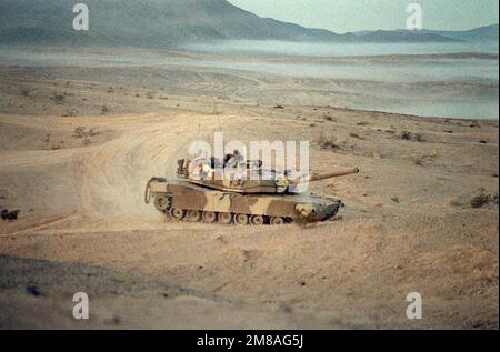 Ein M-1A1 Abrams Hauptwaffenpanzer der 24. Infanteriedivision (mechanisiert) wartet während einer Feuerübung im National Training Center in Position. Basis: Fort Irwin Bundesstaat: Kalifornien (CA) Land: Vereinigte Staaten von Amerika (USA) Stockfoto