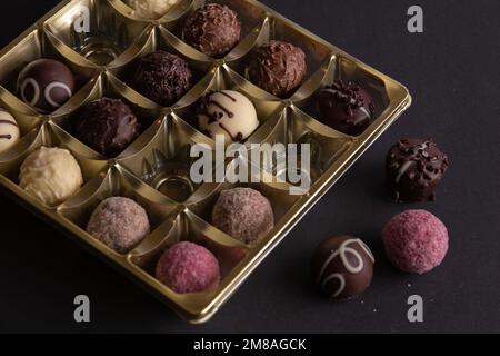 Foto von vielen verschiedenen Pralinen, die in einer Schachtel liegen, mehrere verschiedene Pralinen, die nebeneinander liegen Stockfoto