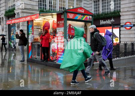 Mitglieder der Öffentlichkeit spazieren am 12. Januar 2023 in London durch einen nassen Piccadilly Cicus in Westminster während einer Woche starken Regens in der Hauptstadt. Stockfoto