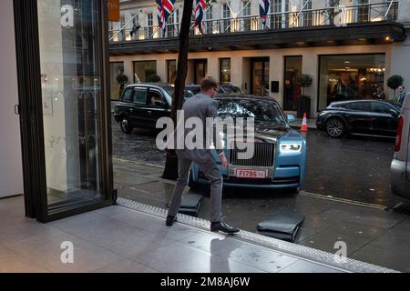 Ein Mitarbeiter von Rolls-Royce führt einen gebrauchten Rolls-Royce Phantom-Limousinenwagen der achten Generation am 12. Januar 2023 in London, England, in den Ausstellungsraum des Unternehmens, um ihn einem potenziellen Kunden auf der Berkley Street in Mayfair zu zeigen. Stockfoto