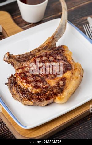 Gegrilltes Kalbfleisch auf weißem Porzellanteller auf Holztisch Stockfoto