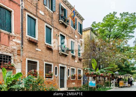 Eine malerische Straße namens „Rio Terà dei Pensieri“ mit venezianischer Flagge, Pflanzen und Vegetation im viertel Dorsoduro, Stadtzentrum von Venedig, Italien Stockfoto
