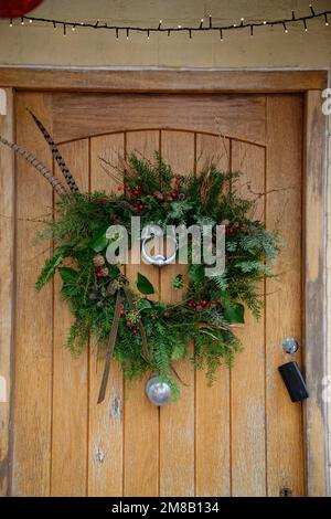 Ein Weihnachtskranz auf einer Holztür. Stockfoto