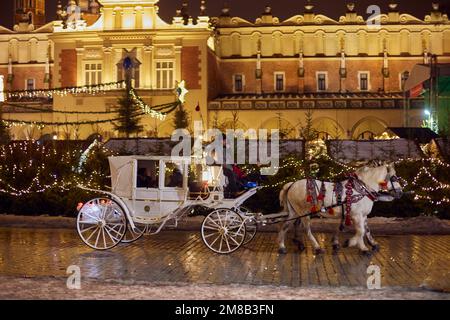 Weiße Pferde- und Kutschfahrten in Krakau auf Rynek Glowny. Stockfoto
