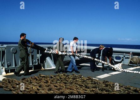 Besatzungsmitglieder fälschen während der Bergungsarbeiten ein Abschleppseil auf dem Deck des Bergungsschiffs USS GREIF (ARS-51), um den Zerstörer USS SPRUANCE (DD-963) zu befreien. Die SPRUANCE lief am 25. Januar 1989 vor Andros Island auf den Bahamas auf Grund. Land: Atlantik (AOC) Stockfoto