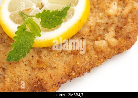 Wiener Schnitzel mit Zitrone und Zitronenbalsam Stockfoto