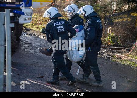 Polizisten nehmen einen Aktivisten weg, die Polizei begann heute, die Stadt Luetzerath zu räumen, am 11. Januar 2023, die Stadt Luetzerath auf der Westseite der Garzweiler-Braunkohlemine wird im Januar 2023 ausgegraben, Luetzerath, am 11. Januar 2023, Stockfoto