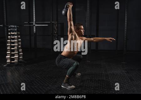 Cross-FIT-Training im Fitnessstudio. Kettlebells Swing Training für Männer im Fitnessstudio. Stockfoto