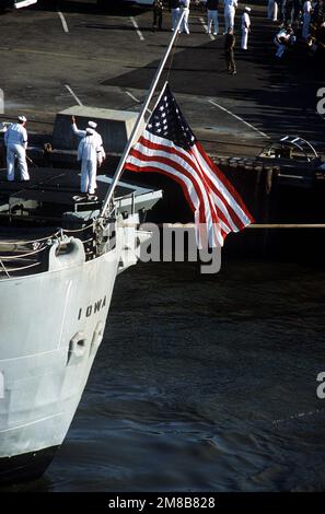 Die amerikanische Flagge fliegt mit Halbmast vom Heck des Schlachtschiff USS Iowa (BB-61), während das Schiff nach einer Exposion, bei der 47 Besatzungsmitglieder ums Leben kamen, in den Heimathafen zurückkehrt. Die Explosion ereignete sich im Geschützturm Nr. 2 16, als die Iowa am 19. April Routineübungen rund 300 Meilen nordöstlich von Puerto Rico durchführte. Basis: Marine Air Station, Norfolk Bundesstaat: Virginia (VA) Land: Vereinigte Staaten von Amerika (USA) Stockfoto