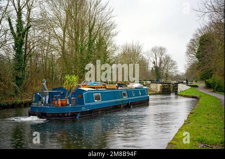 Hanwell Locks am Grand Union Canal in Hanwell, Greater London, Großbritannien. Ein Kanalboot, das im Regen durch Schleuse Nummer 96 fährt. Stockfoto