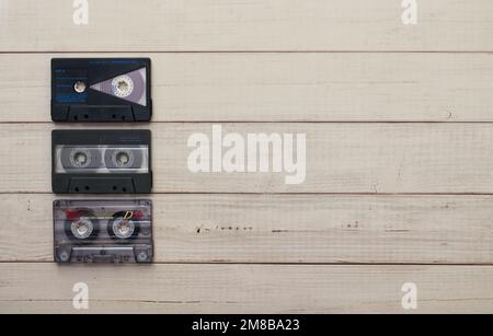 Vintage-Audiokassette auf Holzhintergrund. Draufsicht. Flach Verlegt. Klassisches Technologiekonzept. Stockfoto