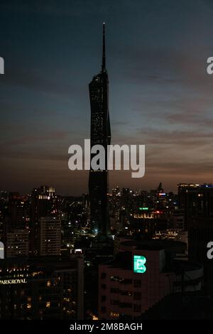 Eine vertikale Aufnahme der Silhouette des Warisan Merdeka Tower in Kuala Lumpur während des Sonnenuntergangs Stockfoto