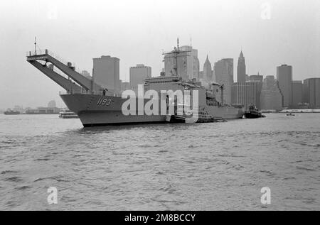 Schleppboote führen das Panzerlandeschiff USS FAIRFAX COUNTY (LST 1193) nach der Parade der Schiffe zu Beginn der Flottenwoche zu seinem Liegeplatz an einem Pier in Brooklyn. Basis: New York Staat: New York (NY) Land: Vereinigte Staaten von Amerika (USA) Stockfoto