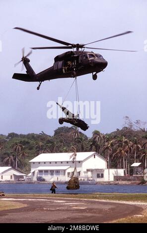 Ein UH-60 Black Hawk (Blackhawk) Helikopter trägt einen M-102 105mm Howitzer und versorgt ihn auf einer Schlinge im Jungle Operations Training Center während der Übung Nimrod Dancer. Betreff Operation/Serie: NIMROD TÄNZERBASIS: Fort Sherman Country: Panama (PAN) Stockfoto