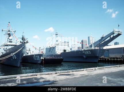 Steuerbord-Bugblick von links: Die geführte Raketenfregatte USS SIMPSON (FFG-56), die Fregatte USS MCCLOY (FF-1038) und das Panzerlandeschiff USS FAIRFAX COUNTY (LST-1193), die während der Flottenwoche am Pier in Brooklyn vor Anker lagen. Staat: New York (NY) Land: Vereinigte Staaten von Amerika (USA) Stockfoto