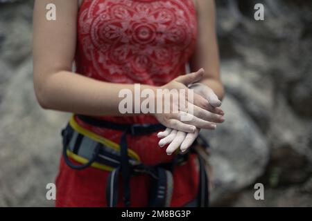 Eine Nahaufnahme der Hände einer Klettererin, bedeckt mit Kletterkreide. Stockfoto