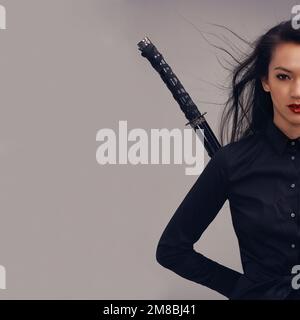 Samurai, Ninja und Porträt einer Frau mit Schwert im Studio isoliert auf grauem Hintergrund. Gesicht, Sport und Kampfkunst junger Kriegerinnen Stockfoto